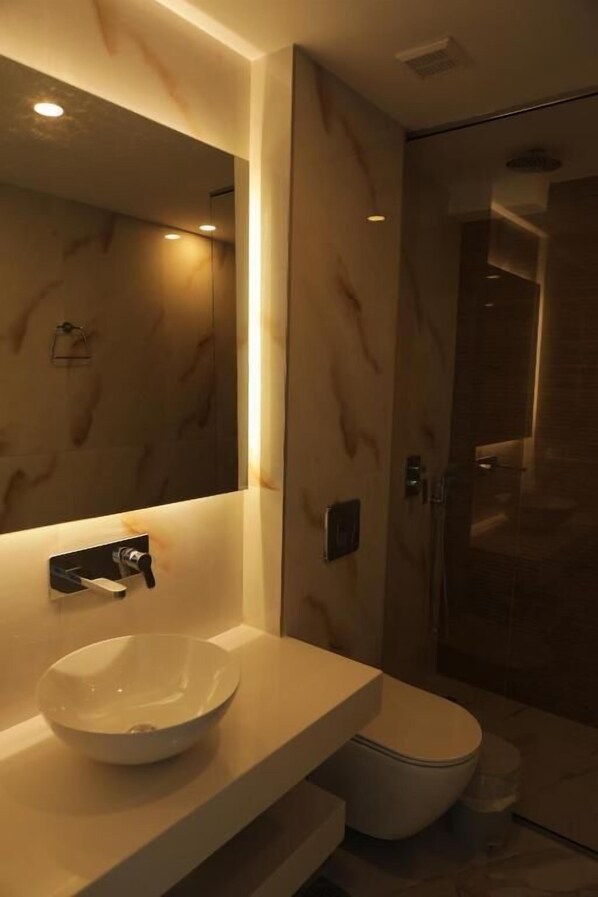 A modern bathroom with a marble vanity, a large mirror, and a glass shower enclosure. - Maria Apartments by Checkin (Hersonissos)