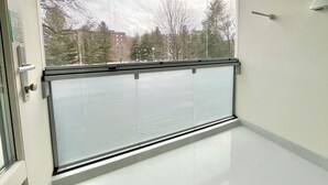 A room with a large window, a door with a handle, and a light switch on the wall. - City Home Finland (Tampere)