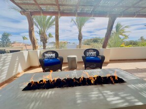 A terrace with two wicker chairs, a small table, and a fire feature. - Near Beach Casita With Firepit (Los Barriles)