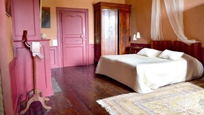 A bedroom with a bed, a wardrobe, a nightstand, and a lamp. - Château de la Motte Beaumanoir (Pleugueneuc)