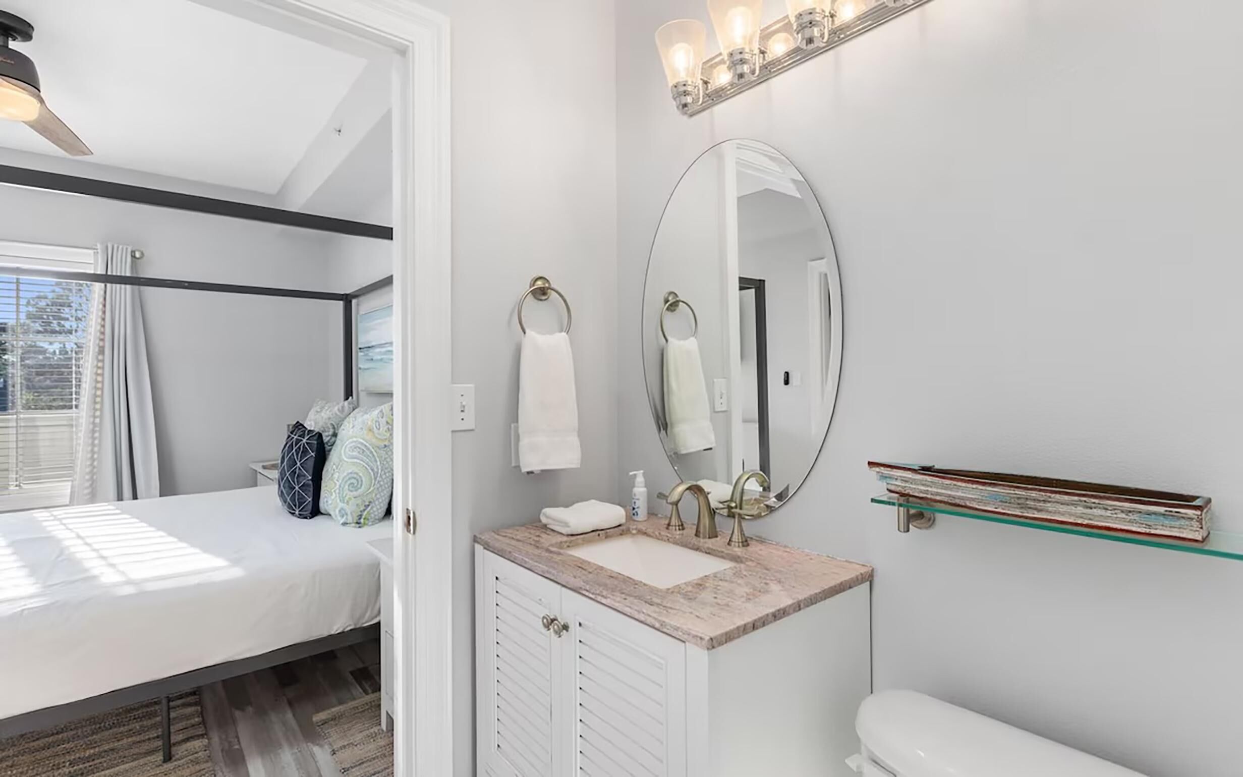 Un baño moderno con tocador, inodoro y un espejo grande.