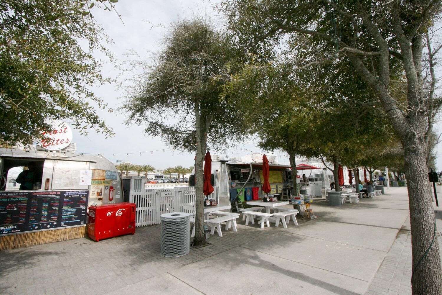 Un marché de stands de nourriture de rue, avec des étals, des tables et des chaises.