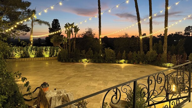 An outdoor patio area with string lights, palm trees, and a paved floor. - Marvelous 11-bedroom villa in Escondido (Escondido)