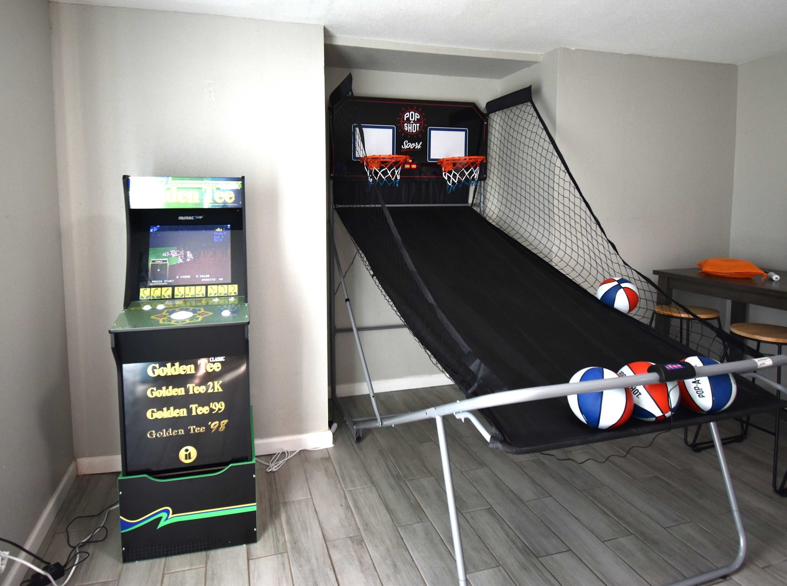 A room with a gaming machine, a slide, and a table with volleyballs.