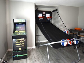 A room with a gaming machine, a slide, and a table with volleyballs. - Large Home in Aurora with Reservoir View (Aurora)