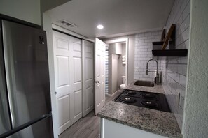 A compact kitchen with a refrigerator, a stove, and a sink. - Large Home in Aurora with Reservoir View (Aurora)