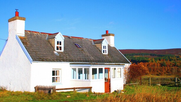 A white house with a grey roof, two chimneys, and a small window. - Strathnoon (Inverness)