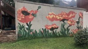 A mural of red and yellow flowers on a concrete wall. - Villa Dallavalle Inn Room 4 (Silverton)