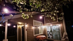 An outdoor patio area with string lights and a table. - Casa de gato (Westminster)