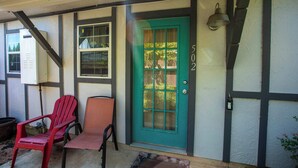 A house with a green door, numbered 5022, and two chairs outside. - Tiled Shower, Walk to Main, Kitchenette, Smart TV (Fredericksburg)