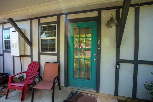A house with a green door, numbered 5022, and two chairs outside. - Walk to Main, Tiled Shower, Smart TV, Queen Bed (Fredericksburg)
