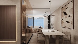 Un comedor moderno con una mesa larga, sillas y vista al mar.