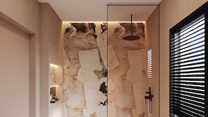 Un baño moderno con un diseño único de pared de piedra, un lavabo empotrado y una ventana con persianas.