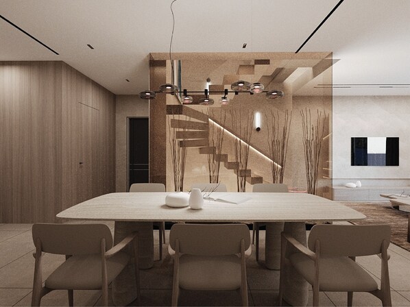 A modern dining area with a large rectangular table, six chairs, a chandelier, and a staircase with a glass railing. - Ionian Premium Villas (Sarande)