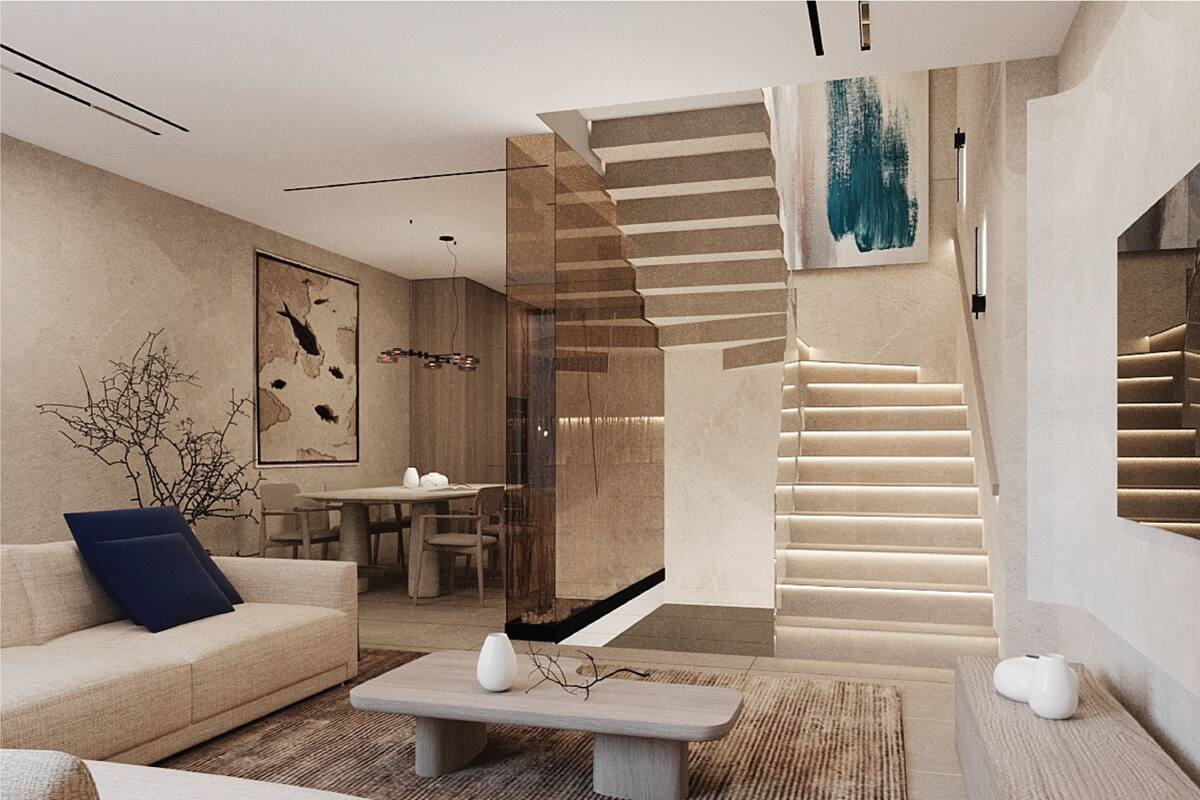 A modern living room with a sofa, coffee table, and a staircase leading to an upper level.