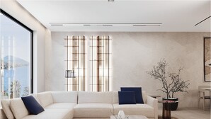 Una sala de estar moderna con un sofá seccional, una mesa de centro y un ventanal con persianas verticales.