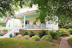 A two-story house with a front porch, a flag, and a brick foundation. - Chesapeake Charm Estate, Two Blocks from the Beach (Cape Charles)