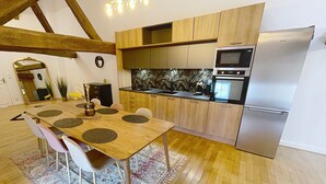 Una cucina moderna con mobili in legno, un frigorifero in acciaio inossidabile e un forno integrato.