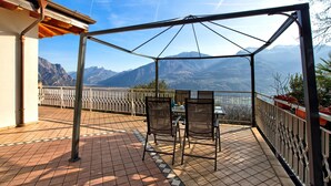 Une terrasse avec une table et des chaises, donnant sur un paysage montagneux.