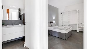 A modern bedroom with a bed, bedside table, and a wardrobe.