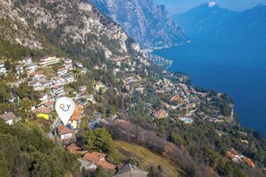 Un village côtier avec des maisons construites sur une colline, un grand plan d’eau et un repère blanc bien visible.