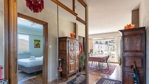 Ruime kamer met een grote spiegel, houten meubels en uitzicht op buiten.