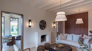 A modern living room with a fireplace, a round dining table, and a sofa.