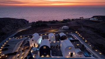 A coastal property with multiple dome-shaped buildings, a swimming pool, and a road leading to the entrance.