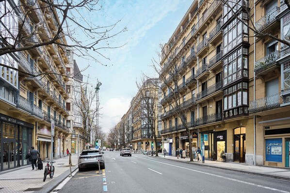 A street lined with multi-story buildings, some with balconies.