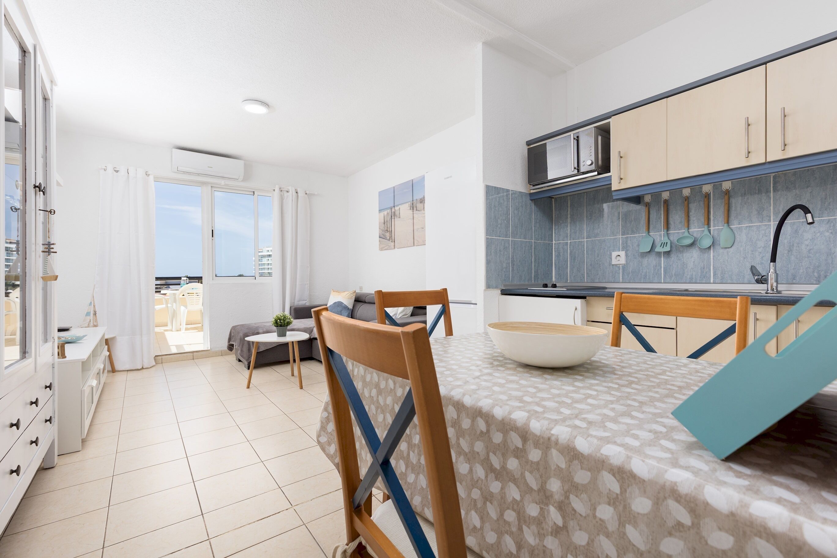 Una cucina moderna con zona pranzo, caratterizzata da un'ampia finestra, un tavolo con sedie e vista sull'esterno.