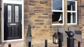 A stone building with a black door labeled "DINGUARD" and a window with a sail. - Dinguardi (Seahouses)