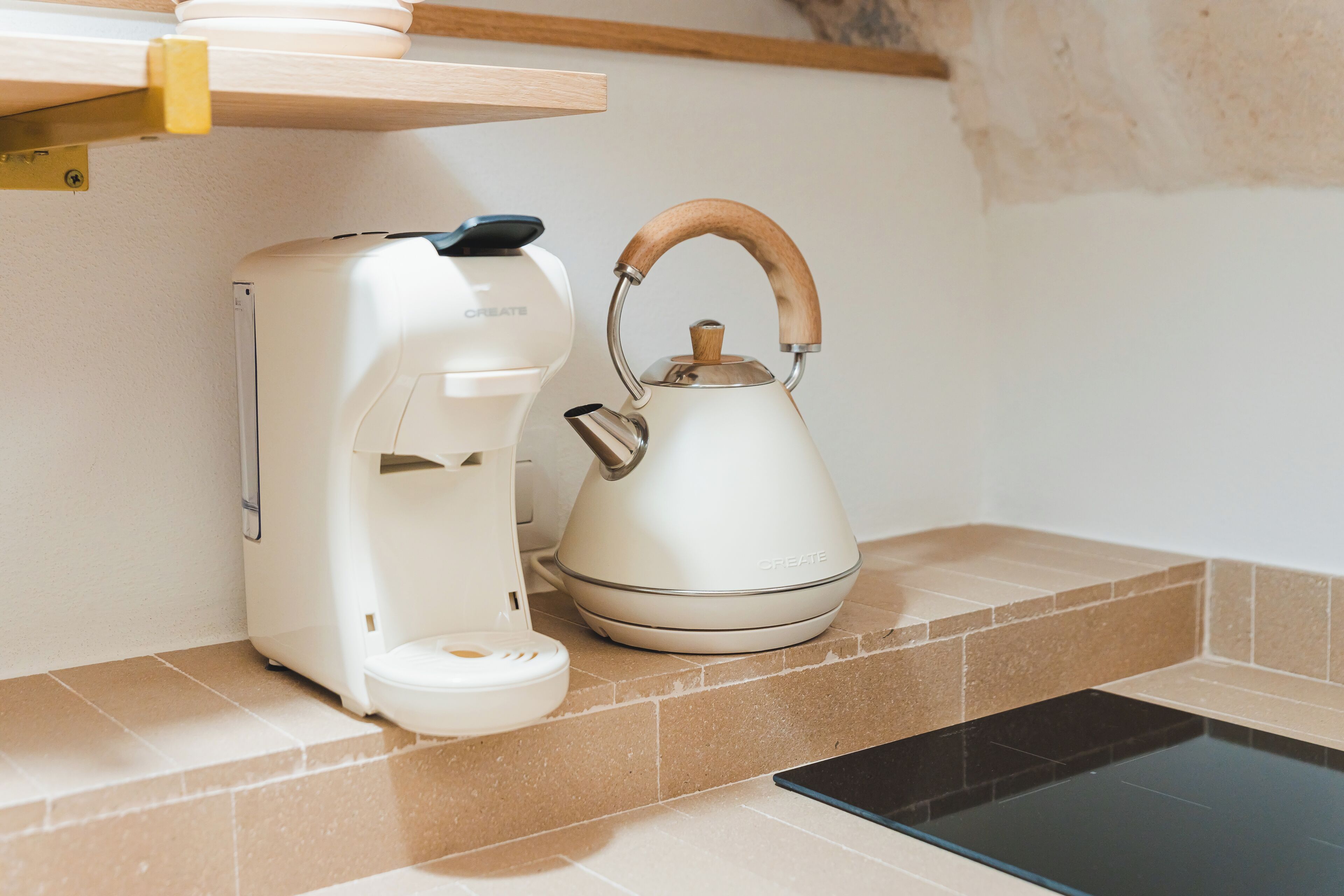 Una cocina con cafetera y hervidor en la encimera.