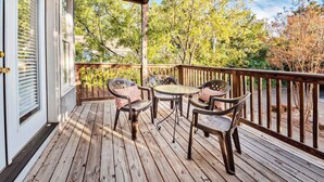 A wooden deck with a table and chairs, surrounded by a wooden railing.