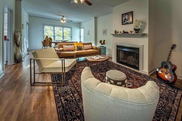 A spacious living room with a fireplace, a sofa, a coffee table, and a guitar. - The Joshua Tree -Unit A by Apex Short Term Stays (Oxford)