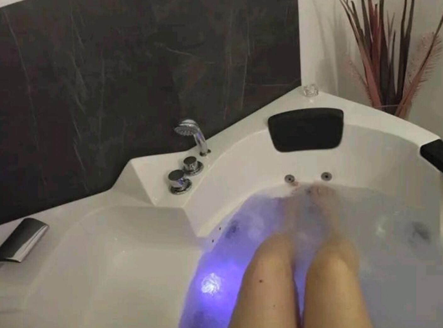 Una vasca da bagno con doccetta manuale e pannello di controllo.