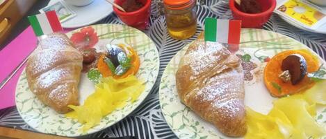 A tray with two plates of food, each with a flag, a cup, and a jar of honey.