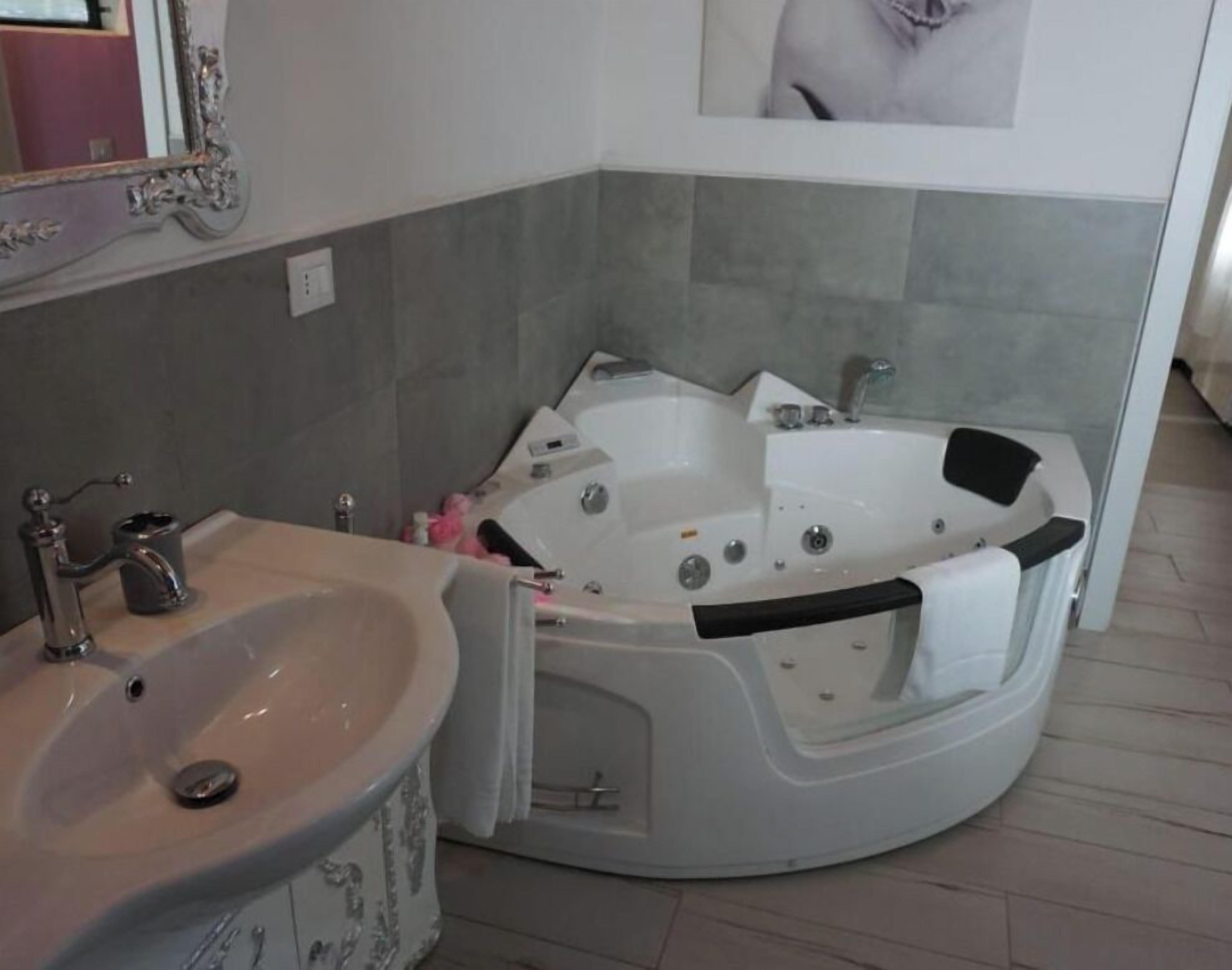 A bathroom with a sink, a bathtub, and a mirror.