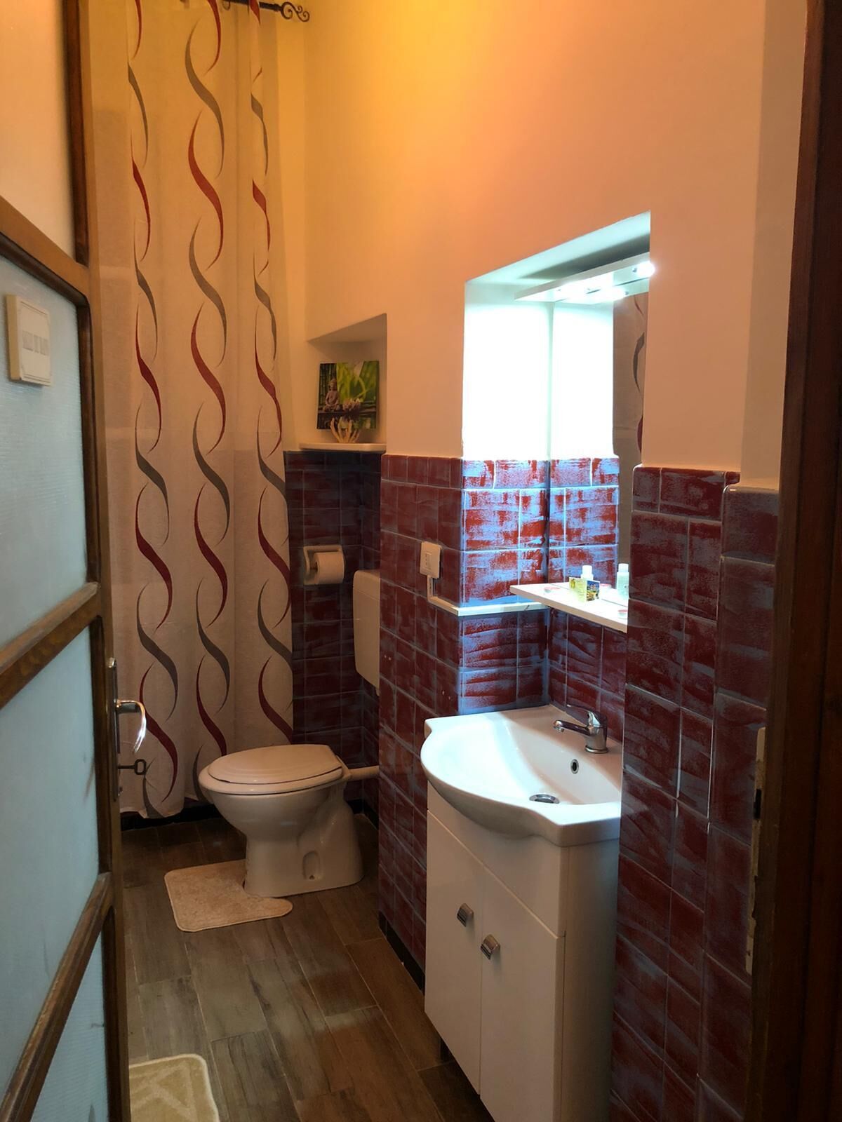 A bathroom with a toilet, sink, and shower curtain.