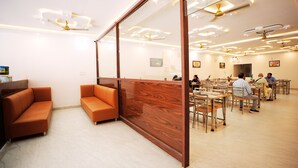 Een modern interieur met zithoeken en tafels, met plafondventilatoren en inbouwverlichting.