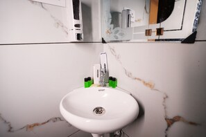 Ein weißes Waschbecken mit einem Spiegel darüber.