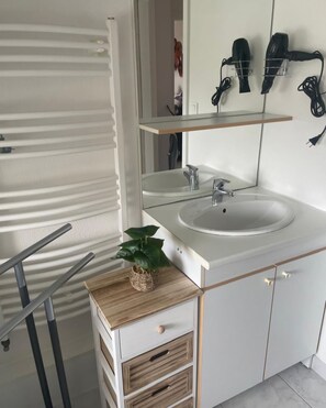 A modern bathroom with a white sink, mirror, and towel rack. - Le square Spacious apartment with terrace & garage, quiet location near Colmar  (Sundhoffen)