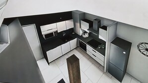 A modern kitchen with white cabinets, black countertops, and stainless steel appliances. - Le square Spacious apartment with terrace & garage, quiet location near Colmar  (Sundhoffen)