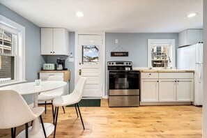 A modern kitchen with white cabinets, a stainless steel oven, and a coffee maker. - Steps to Beach & Downtown OGT (Ogunquit)