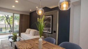 A modern dining area with a wooden table, woven placemats, and two pendant lights. - H106 - Amazing Comfort & Amenities, Pool, Security (Cali)