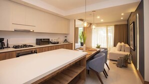 A modern kitchen with a central island, built-in appliances, and pendant lighting. - H106 - Amazing Comfort & Amenities, Pool, Security (Cali)