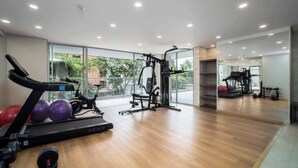 Ein modernes Fitnessstudio mit Laufband, Crosstrainer und Kraftgeräten.