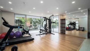 A modern gym with a treadmill, exercise balls, and weight machines.
