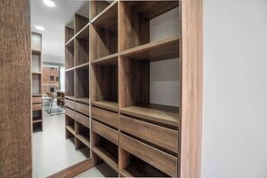 Um interior moderno com uma estante de madeira em frente a uma parede branca.