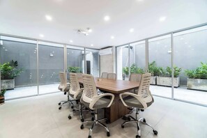 A conference room with a large table and six chairs.
