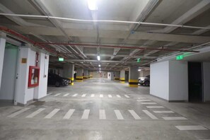 Um parque de estacionamento com vários níveis, pisos de betão e paredes brancas.
